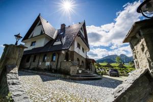 a large house with the sun in the sky at Apolonia Willa in Zakopane