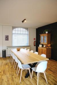 Un comedor con una mesa de madera y sillas blancas. en Vakantiewoning Villa Elena, en Nieuwpoort