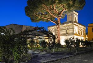 un edificio con un árbol delante en Villa Silvana, en Boscoreale