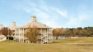 a large white building with a tower on top at Holiday Inn Club Vacations Piney Shores Resort at Lake Conroe in Conroe