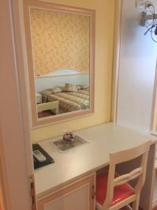 una camera da letto con tavolo da trucco e specchio di Albergo La Pineta a Cingoli