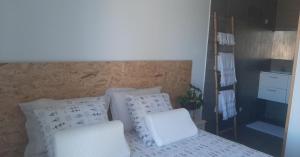 a bedroom with a bed with pillows and a ladder at Chambre Cocooning in Beauvoisin