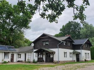 a large white house with a black roof at Siedlisko nad Sapiną in Kruklanki