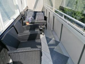 balkon z 2 krzesłami, stołem i kanapą w obiekcie City centre apartment Siilinjärvi w mieście Siilinjärvi