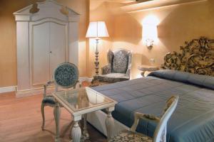 Un dormitorio con una cama y una mesa y sillas. en Villa Silvana, en Boscoreale