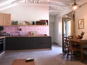 a kitchen with black cabinets and a table with chairs at Rigo’s apartment in Platamonas