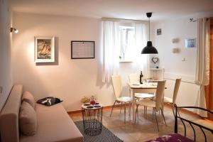 a living room with a couch and a table with chairs at Apartmani Grguric in Kornić