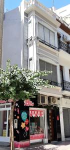 ein Gebäude mit einem Laden mit einem Baum davor in der Unterkunft Apartamento San Pascual en Orihuela in Orihuela