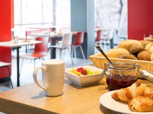 a table with a tray of bread and a plate of food at ibis Hotel München Garching in Garching bei München