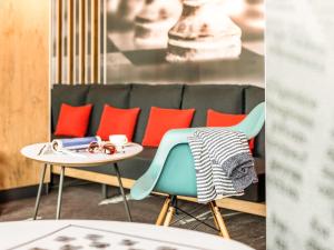 a table and chairs in a room with a couch at ibis Hotel München Garching in Garching bei München