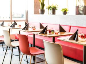 a row of tables in a restaurant with laptops on them at ibis Hotel München Garching in Garching bei München