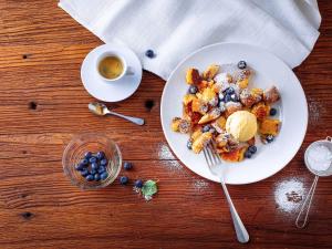 a plate of food with blueberries and a cup of coffee at ibis Hotel München Garching in Garching bei München