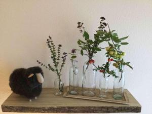 a shelf with vases with flowers and a stuffed animal at ibis Hotel München Garching in Garching bei München