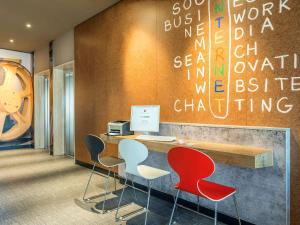 an office with chairs and a desk with a computer at ibis Hotel München Garching in Garching bei München