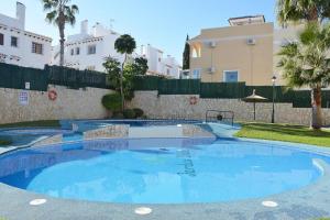 a large blue swimming pool in front of a building at Apartament Jardin De Alba in Villamartin in Orihuela Costa