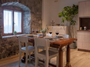 une salle à manger avec une table en bois et des verres à vin dans l'établissement Apartmaji in sobe Odlična hiša Štanjel, à Štanjel