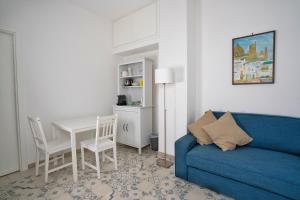 a living room with a blue couch and a table at Le Cantinelle in Anacapri