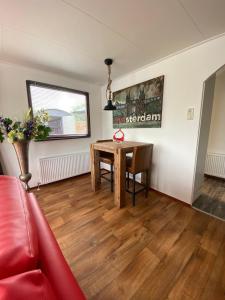 uma sala de estar com uma mesa e um sofá vermelho em C'est la Vie Houseboat em Nederhorst den Berg