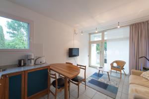 kuchnia i salon ze stołem i kanapą w obiekcie Appartement Lago Blu w mieście Riva del Garda