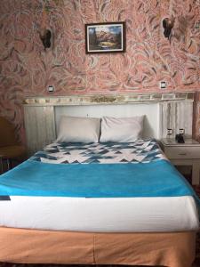a bedroom with a bed with a blue blanket at Antik Otel in Ankara