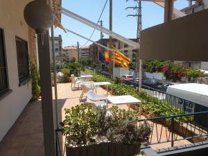 a balcony with tables and chairs on a building at Hotel Sant Jordi in Segur de Calafell