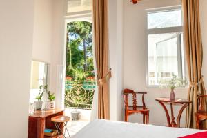 una camera con letto e finestra aperta di Conico Đà Lạt Hotel a Da Lat