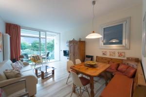 uma sala de estar com uma mesa e um sofá em Appartement Balcone sul Lago em Riva del Garda