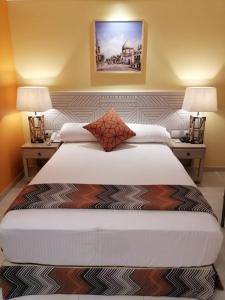 a hotel room with a bed and two lamps at Almadiafa - المضيفه in Cairo