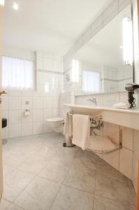 a white bathroom with a sink and a toilet at Haus Shangri-La in Saas-Fee