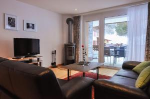 a living room with a couch and a television at Haus Shangri-La in Saas-Fee