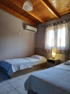 a bedroom with two beds and a window at Vravrona Artemis Home & Transfer Airport in Artemida