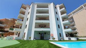 an apartment building with a pool in front of it at Marina Palmanova Apartamentos in Palmanova