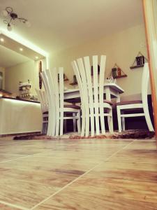 Petrov Apartment في تريفنا: مجموعة من الكراسي البيضاء في غرفة مع طاولة