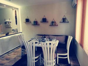 una sala da pranzo con tavolo, sedie e bicchieri da vino di Petrov Apartment a Tryavna