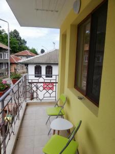 Un balcón con sillas y una mesa y un edificio. en Petrov Apartment, en Tryavna