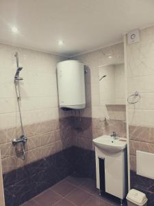 a bathroom with a shower and a toilet and a sink at Petrov Apartment in Tryavna