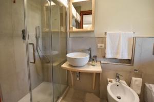 ein Bad mit einem Waschbecken und einer Glasdusche in der Unterkunft B&B I Graniti Sardi in Villasimius