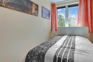 Schlafzimmer mit einem Bett und einem Fenster in der Unterkunft Apartament Alicja II in Danzig