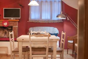 comedor con mesa, sillas y TV en Casa Calvola holiday home, en Tenno