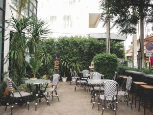 an outdoor patio with tables and chairs and plants at Give Me 5 Hostel in Chiang Mai