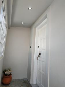 a hallway with a white door and a window at Vravrona Artemis Home & Transfer Airport in Artemida