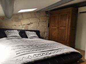 uma cama num quarto com uma parede de pedra em Duplex au Coeur de Lunel em Lunel