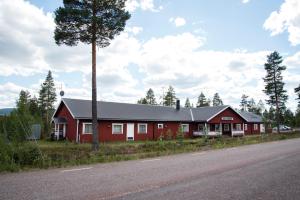 una casa roja al lado de una carretera en STF Vandrarhem Sälen, en Stöten