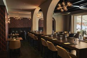 阿斯科納的住宿－阿斯科納廣場餐廳酒店，餐厅设有长桌、椅子和吊灯