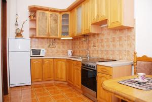 cocina con armarios de madera y nevera blanca en Rentday Apartments - Kiev, en Kiev