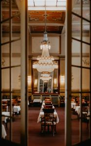 巴特基辛根的住宿－維多利亞凱瑟霍夫酒店，一间带吊灯和桌椅的用餐室