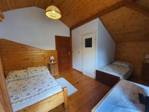 an attic bedroom with two beds and a hallway at Siedlisko nad Sapiną in Kruklanki