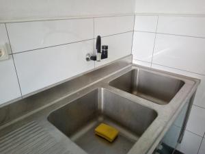 a kitchen sink with a yellow sponge in it at Campingplatz Torrenerhof in Golling an der Salzach