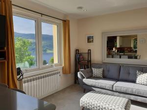 a living room with a couch and a large window at Number 6 in Fort William