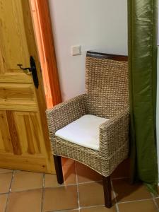 a wicker chair with a white seat next to a door at Ronda in Ronda